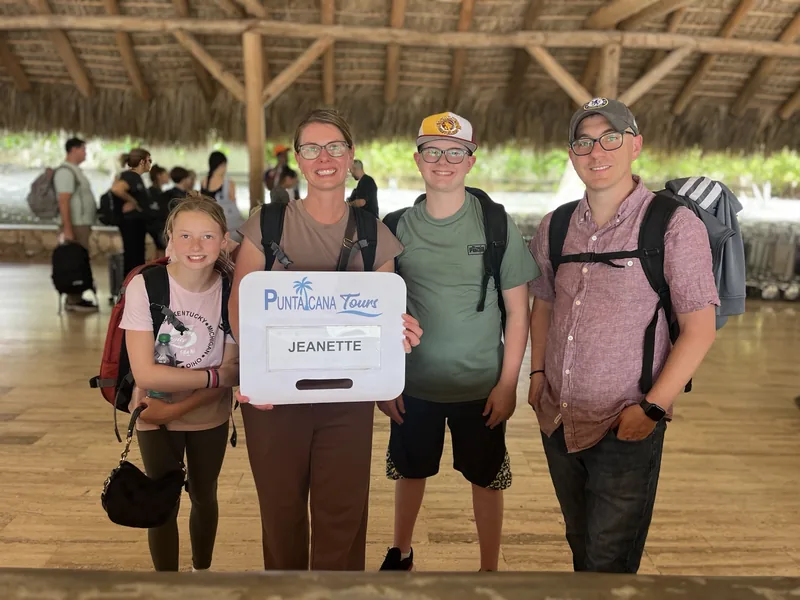 A family met at Punta Cana arrivals by a driver holding a name sign